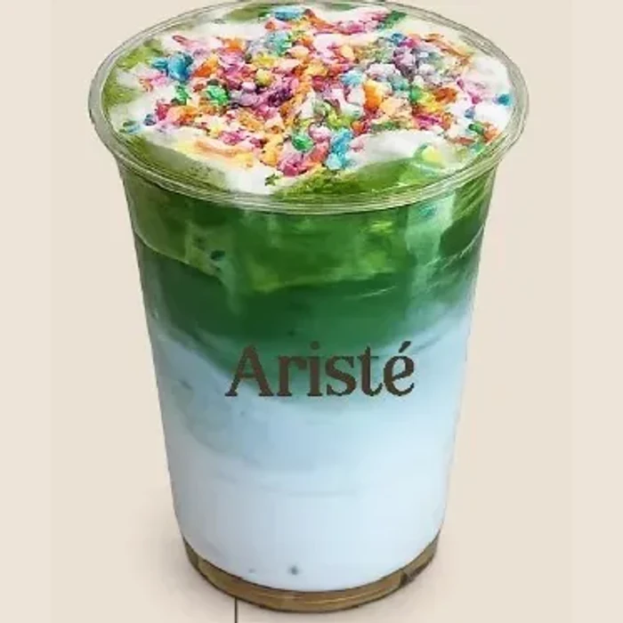 Doorzichtige beker met gelaagde matcha, slagroom en gekleurde cakekruimels