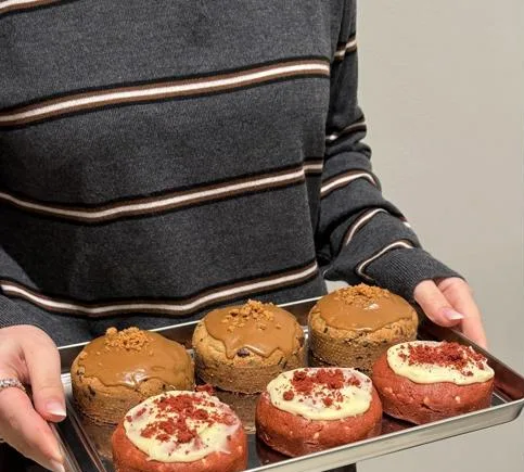 Een bakplaat met zes gevulde cakejes wordt de zaak in gedragen