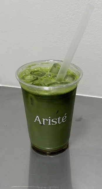 Iced matcha in een Aristé beker op een stalen werkblad