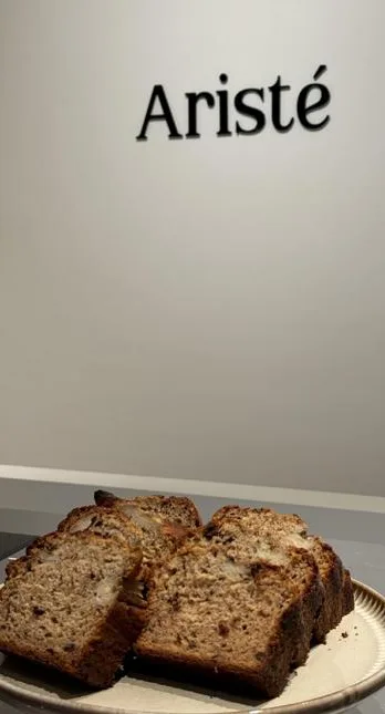 De naam Aristé op de binnenmuur, met plakken bananenbrood op een grijs bord